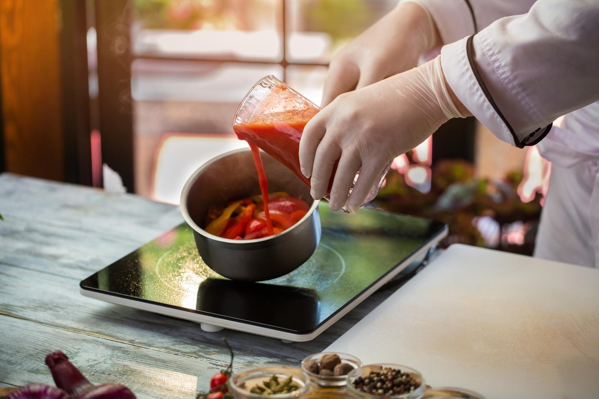Participant hands-on, stirring sauce under instructor supervision