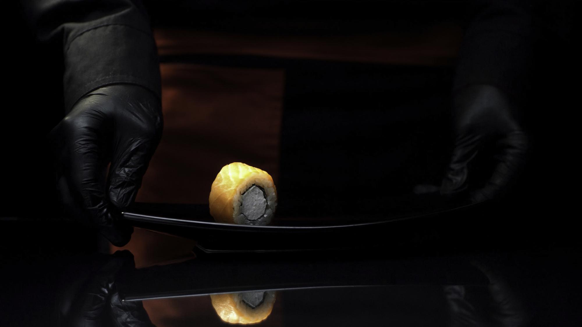 Instructor plating a modern dish with LED-lit kitchen